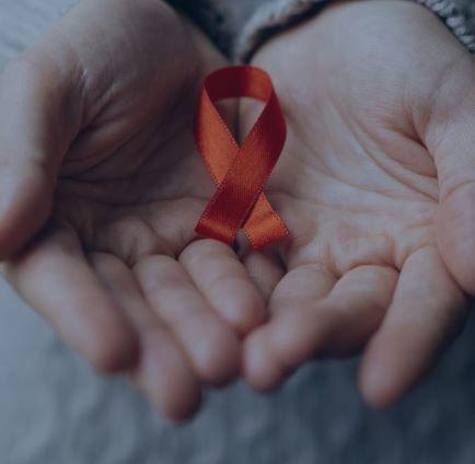 Two male hands holding a red ribbon