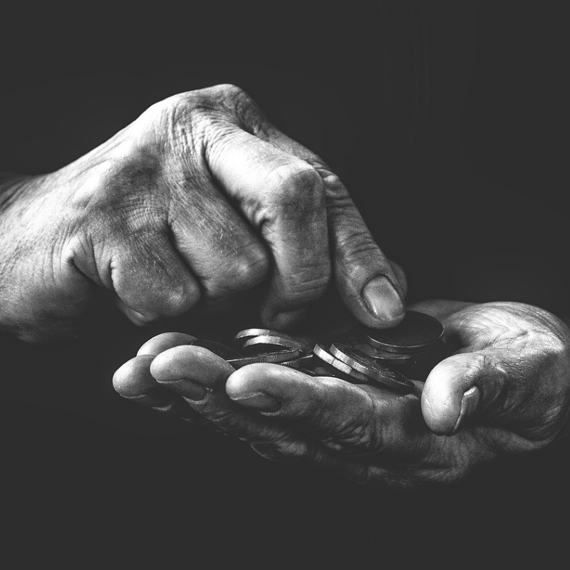 Black and white photograph of some elderly hands holding coins.