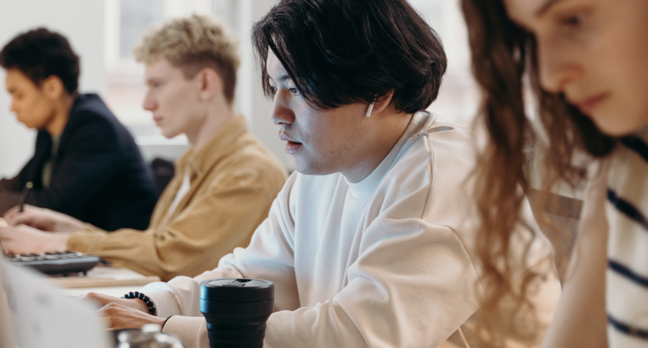 image of 4 young people sat at computers studying