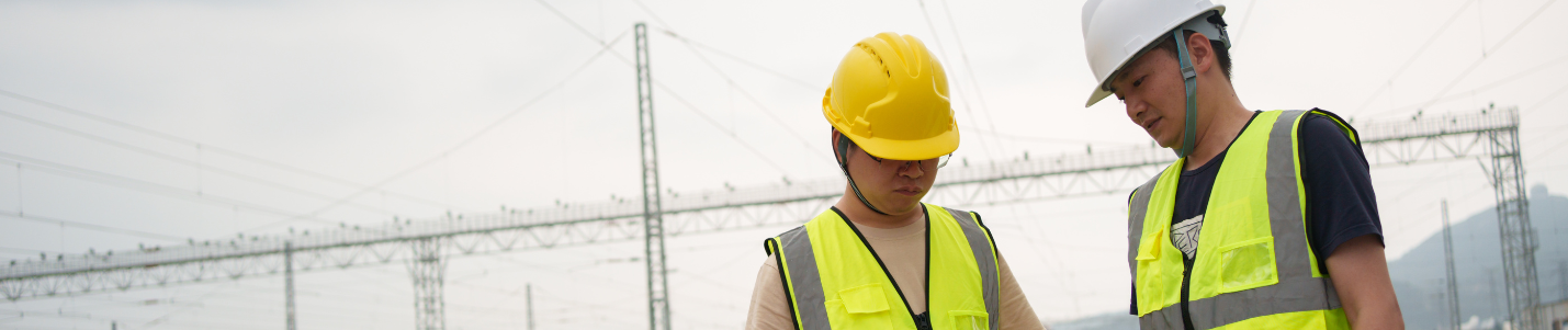 Two people on yellow hi Vis vests and yellow helmets.