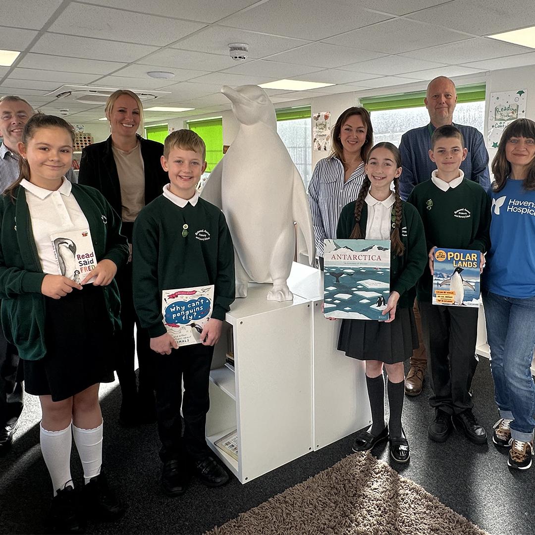 Children and staff from Richmond Avenue Primary and Nursery School, Rickard Luckin and Havens Hospices staff stand with a plaster penguin