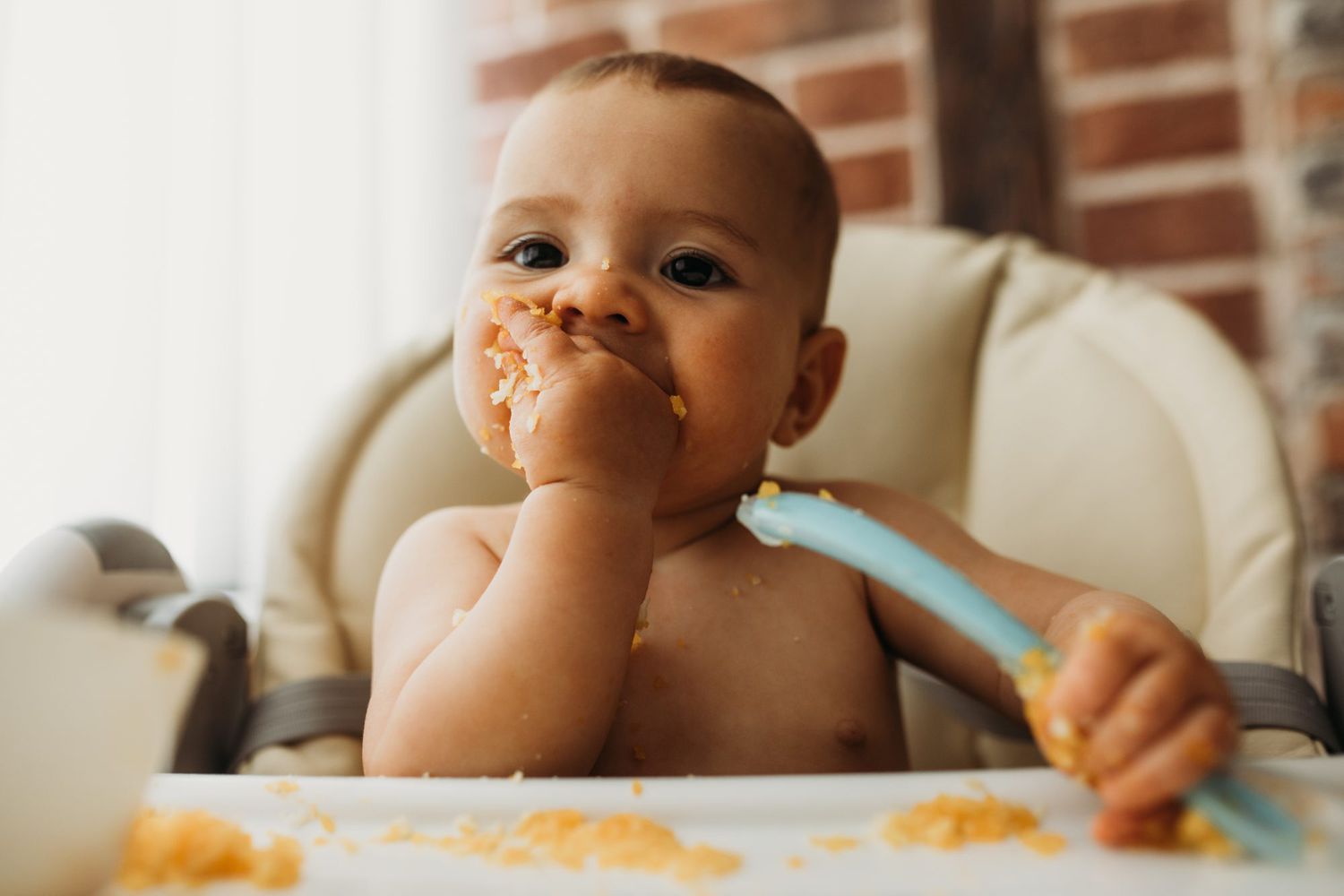 baby in highchair self feeding