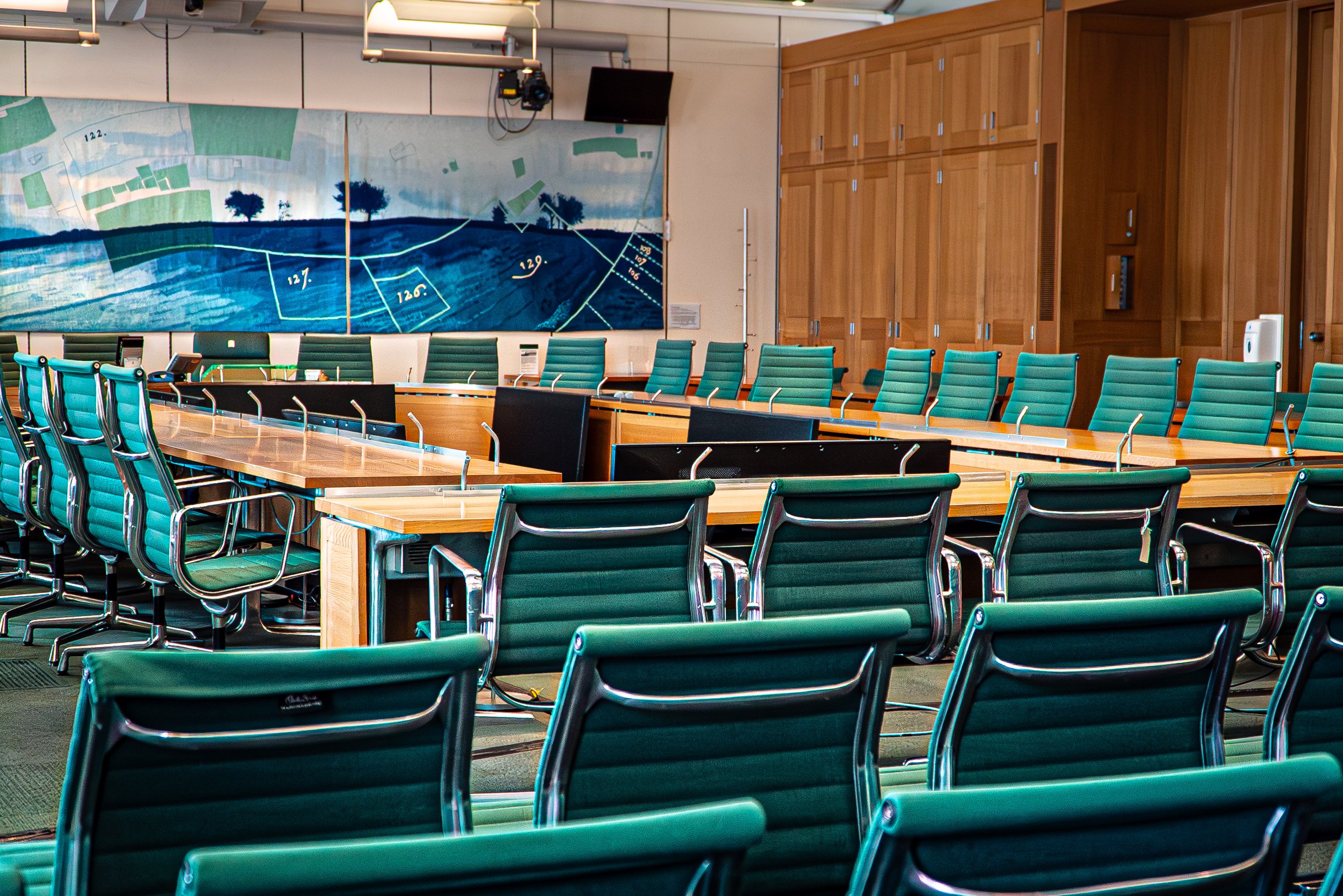 photograph of a meeting room with lots of green chairs.